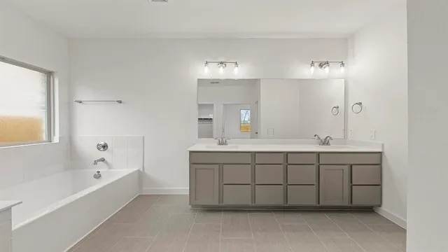 a spacious bathroom with a double vanity sink mirror and a bathtub