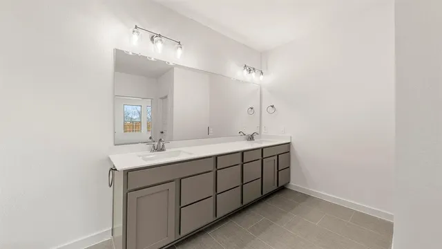 a bathroom with a double vanity sink and a mirror