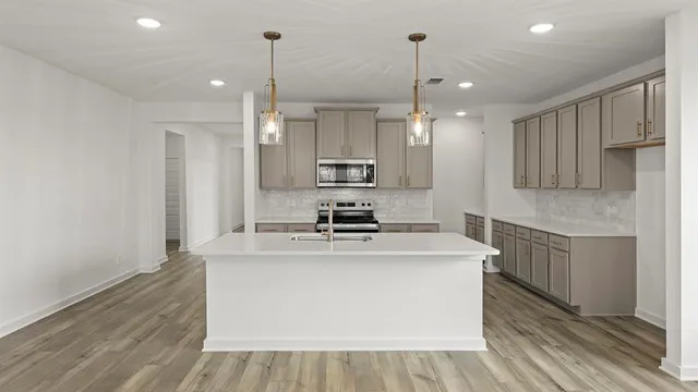 a kitchen with kitchen island a sink stove and refrigerator