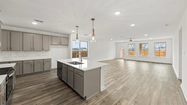 a kitchen with stainless steel appliances granite countertop a stove and a wooden floors