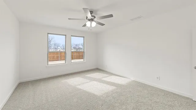 an empty room with windows and fan