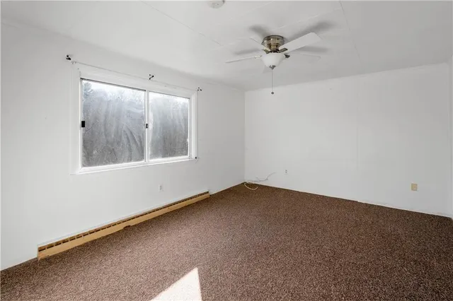an empty room with a window and a ceiling fan
