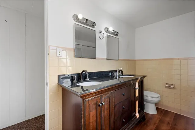 a bathroom with a granite countertop sink a toilet and a mirror