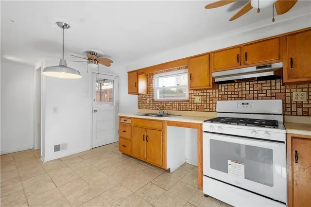 a kitchen with stainless steel appliances granite countertop a stove a sink and a refrigerator