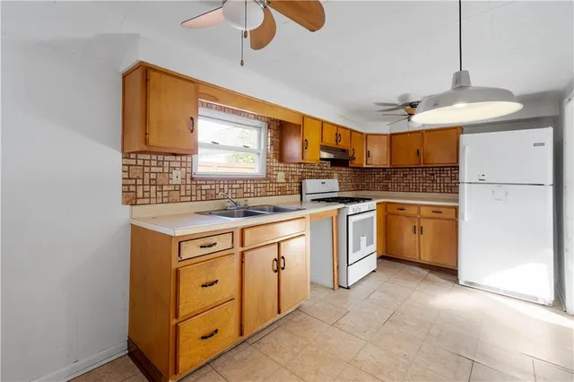 a kitchen with stainless steel appliances granite countertop a stove sink and refrigerator