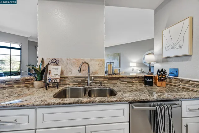a kitchen with granite countertop a sink and cabinets