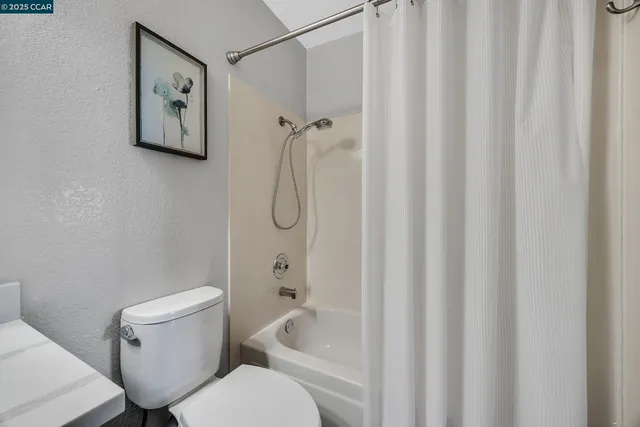 a white toilet sitting next to a bath tub