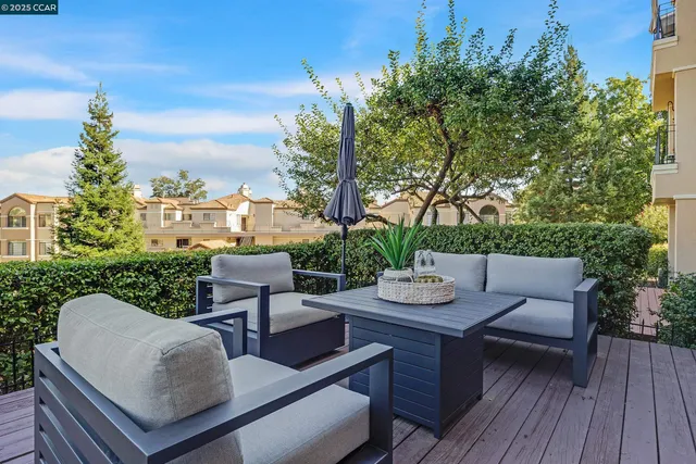 a view of a patio with couches table and chairs and potted plants