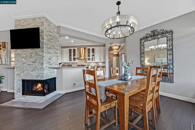a view of a dining room with furniture wooden floor and a fireplace
