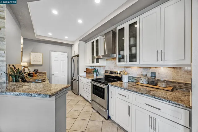 a kitchen with stainless steel appliances granite countertop a stove a sink and a granite counter tops