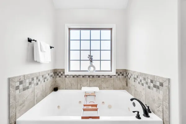 a bathroom with bathtub and window
