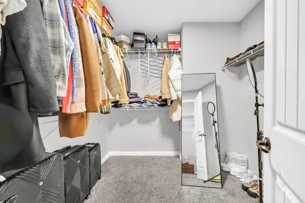 a view of walk in closet with clothes and shoes