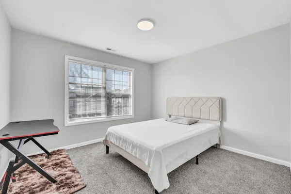 a bed sitting in a bedroom next to a window