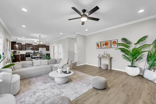 a living room with furniture and a view of kitchen