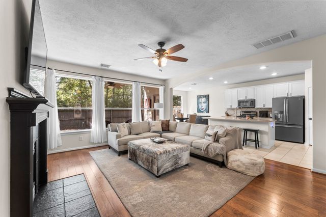 a view of a backyard with a large tree and wooden fence