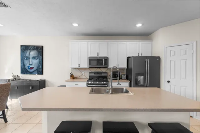 a kitchen with refrigerator cabinets dining table and chairs