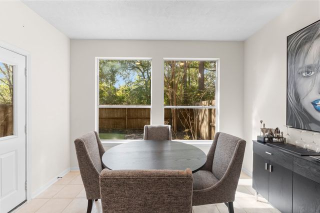 a large kitchen with stainless steel appliances a stove a sink dishwasher a refrigerator and white cabinets with wooden floor