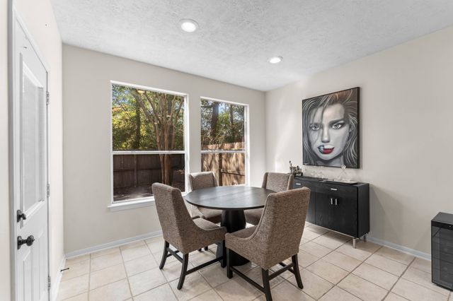 a living room with stainless steel appliances kitchen island granite countertop a dining table chairs and a refrigerator