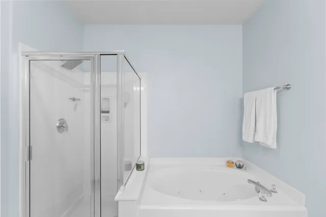 a spacious bathroom with a tub shower sink and mirror