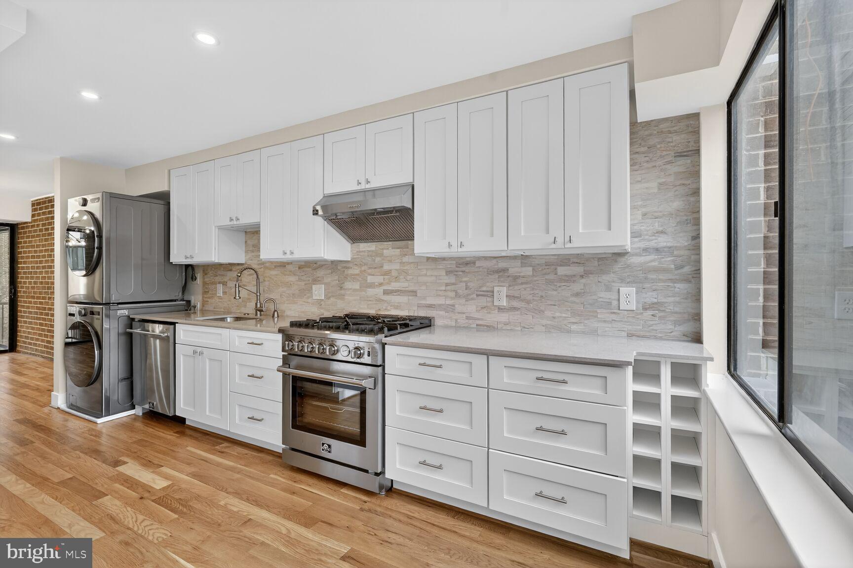 a kitchen with granite countertop a sink stainless steel appliances and cabinets