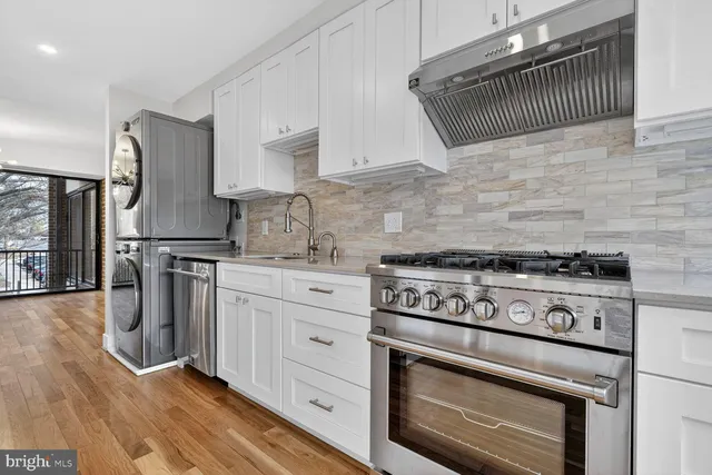 a kitchen with granite countertop a stove a sink and a refrigerator
