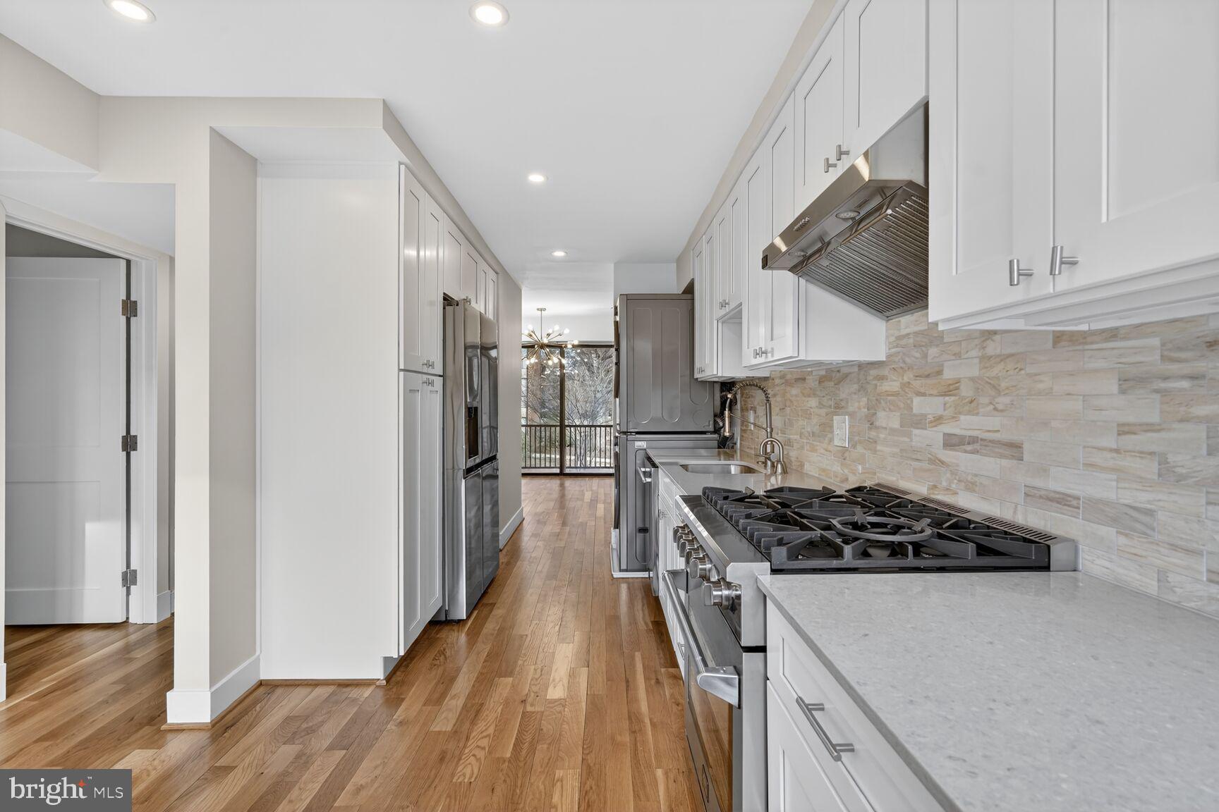 9802 Georgia Avenue, Unit 26202 Silver Spring, MD 20902 - Photo 12 of 31 a kitchen with a stove a refrigerator and a wooden cabinets