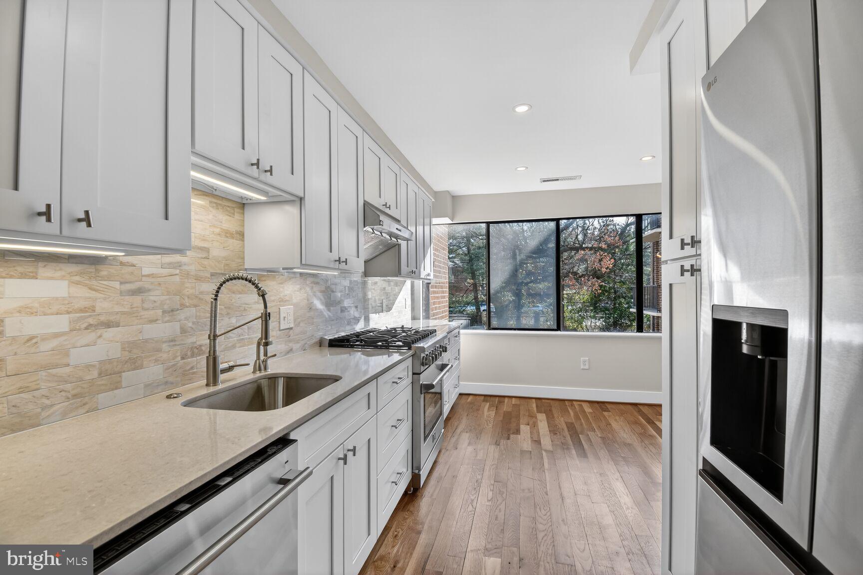 9802 Georgia Avenue, Unit 26202 Silver Spring, MD 20902 - Photo 9 of 31 a kitchen with granite countertop a sink a counter space and cabinets