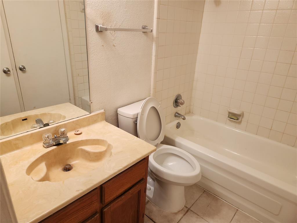 9813 Walnut Street, Unit 104 Dallas, TX 75243 - Photo 16 of 19 a bathroom with a sink a toilet and shower
