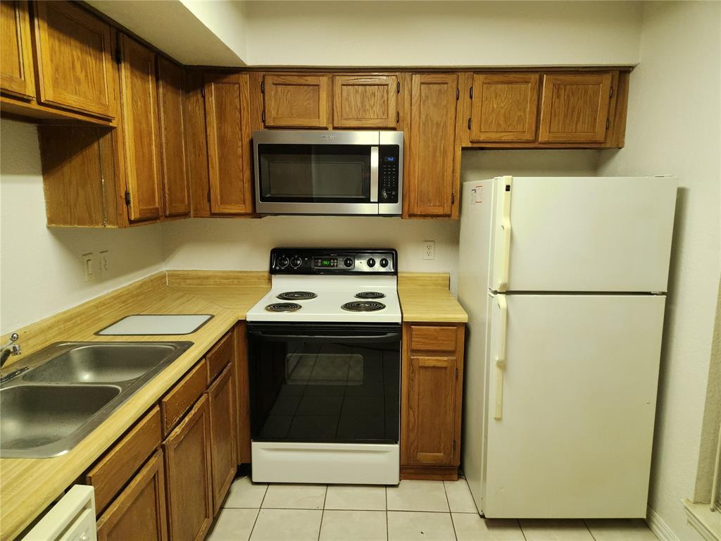 9813 Walnut Street, Unit 104 Dallas, TX 75243 - Photo 2 of 19 a kitchen with a stove refrigerator and microwave