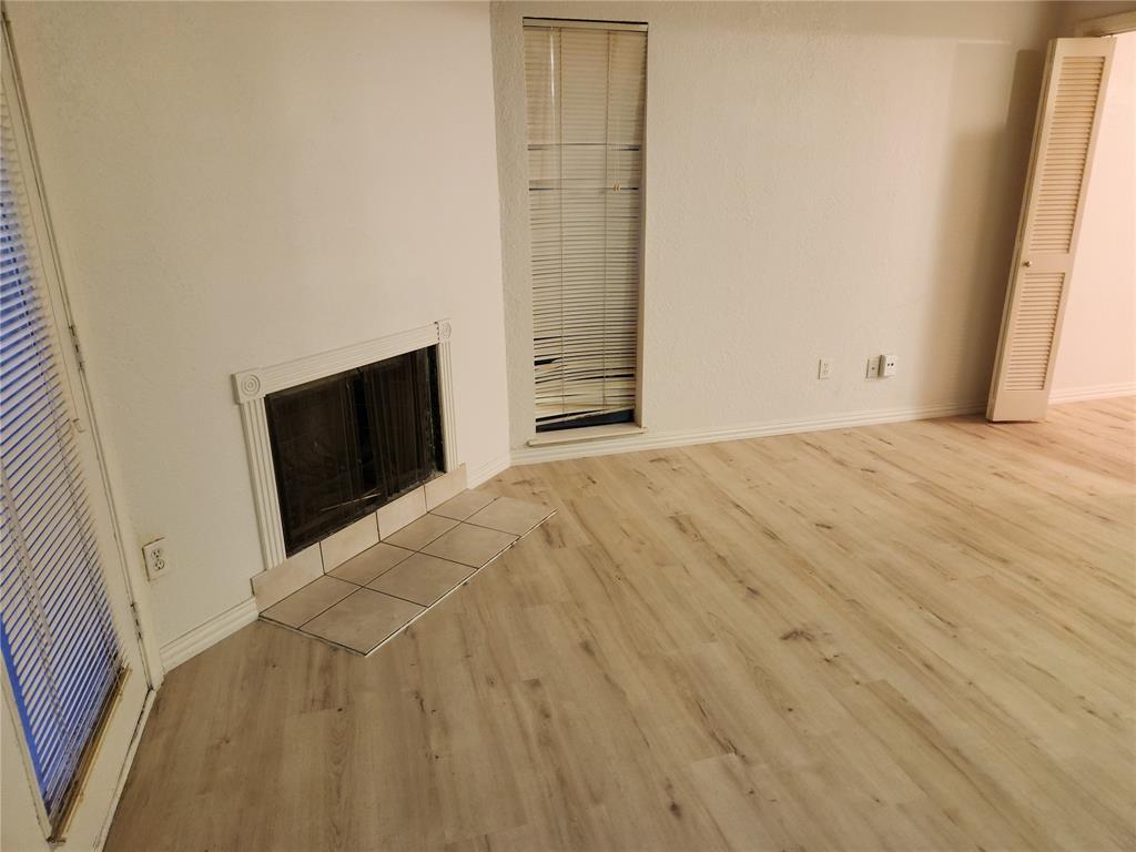 9813 Walnut Street, Unit 104 Dallas, TX 75243 - Photo 5 of 19 a view of an empty room with wooden floor and a window