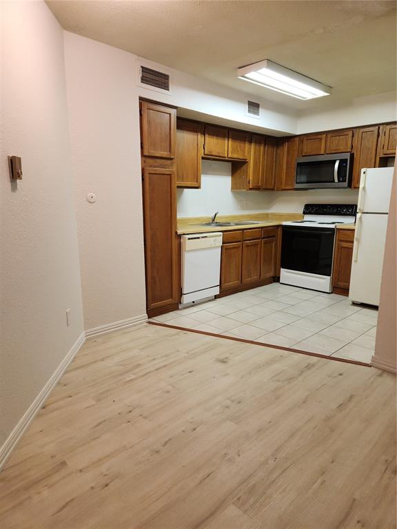 9813 Walnut Street, Unit 104 Dallas, TX 75243 - Photo 7 of 19 a kitchen with stainless steel appliances a refrigerator and a sink