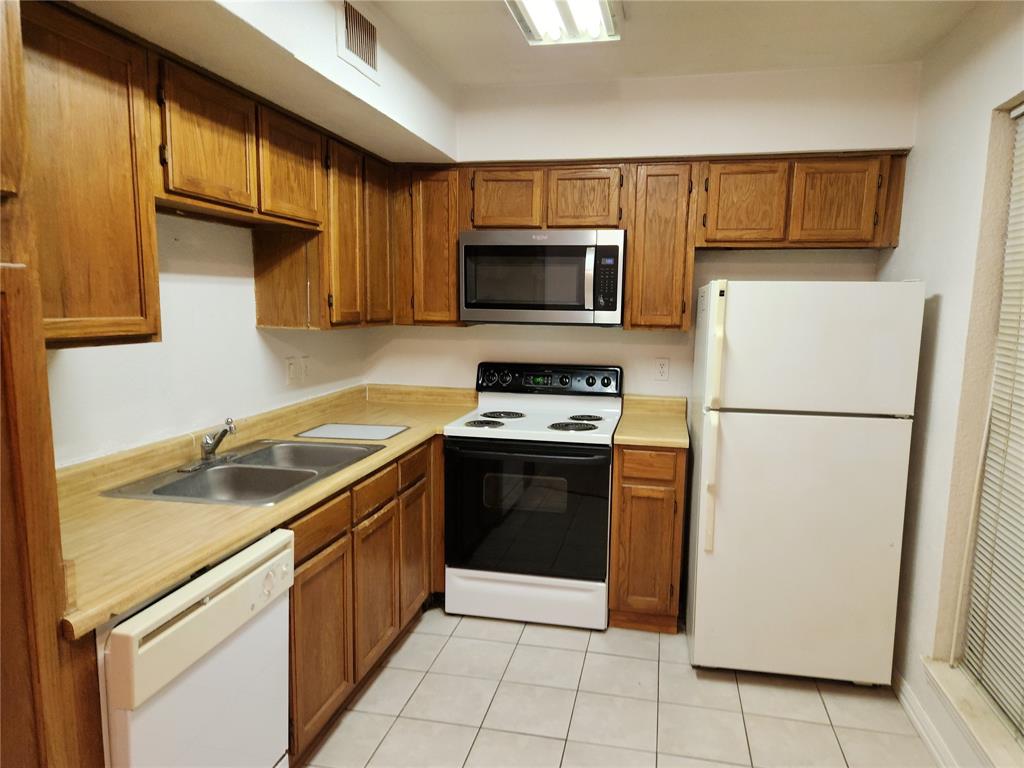 9813 Walnut Street, Unit 104 Dallas, TX 75243 - Photo 8 of 19 a kitchen with a refrigerator sink and microwave