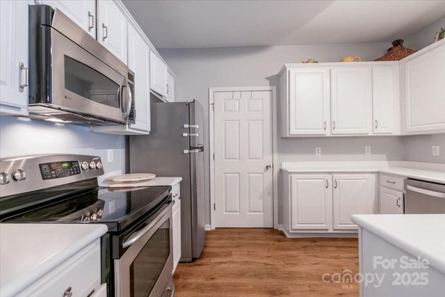 a kitchen with stainless steel appliances granite countertop a stove microwave and refrigerator