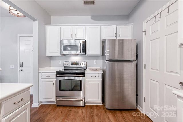 a kitchen with a refrigerator stove and wooden cabinets