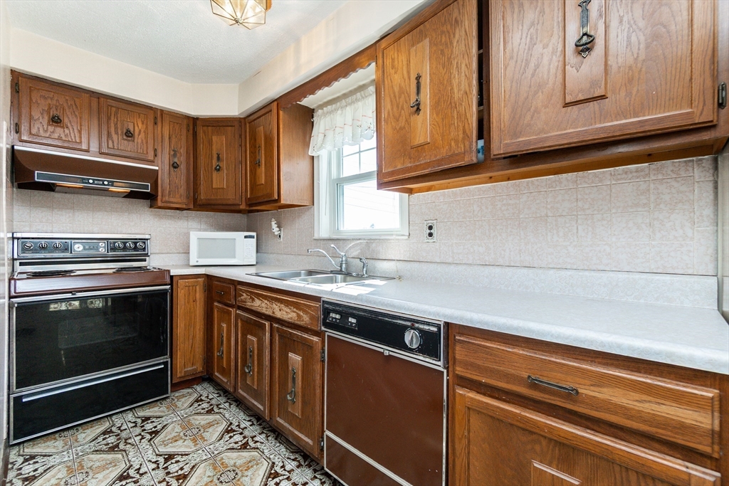 2 Sheldon Road Peabody, MA 01960 - Photo 4 of 42 a kitchen with stainless steel appliances granite countertop a sink stove and cabinets