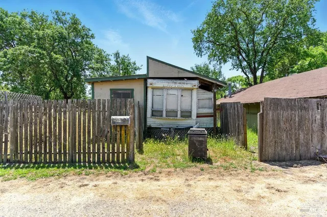 an aerial view of residential houses with outdoor space and trees all around