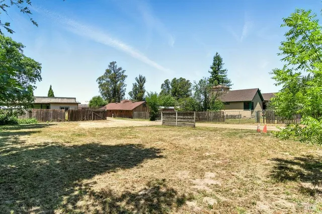 an aerial view of residential house with outdoor space and trees all around