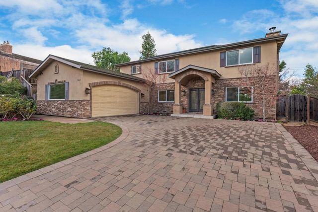 a front view of a house with a garden