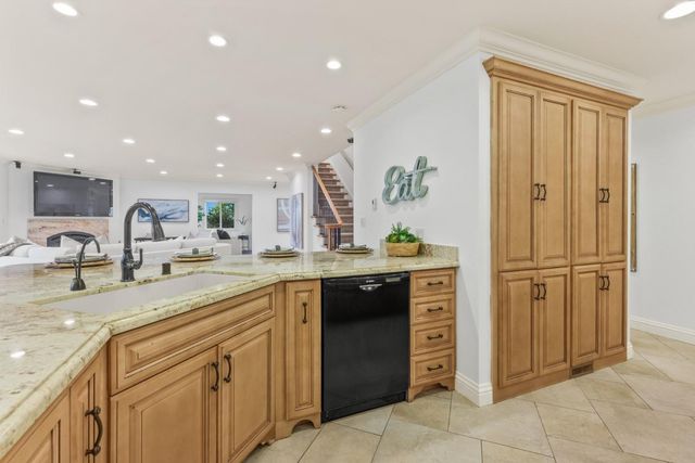 a kitchen with stainless steel appliances granite countertop a refrigerator and a sink