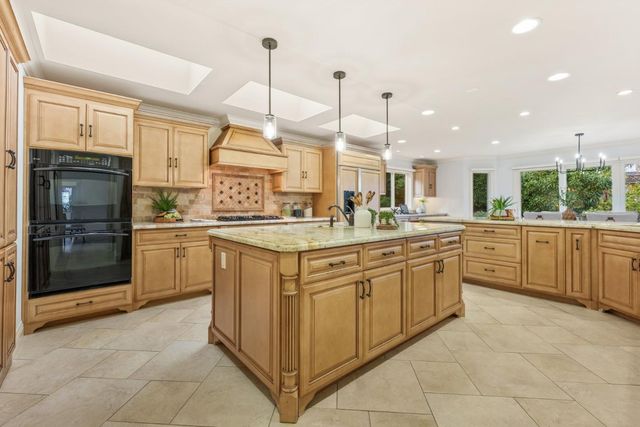 a kitchen with a sink counter top space cabinets and stainless steel appliances