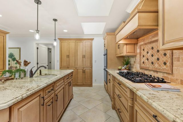 a kitchen with stainless steel appliances granite countertop a stove a sink and a refrigerator