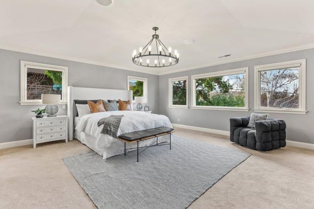 a spacious bedroom with a bed and a chandelier