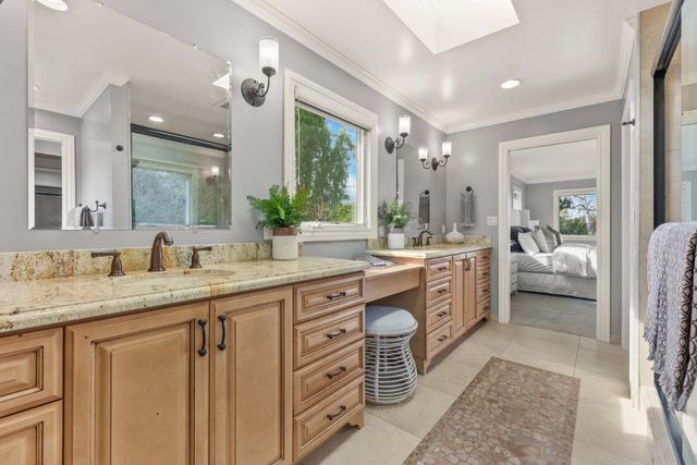 a spacious bathroom with a granite countertop double vanity sink a mirror a vanity and a bathtub
