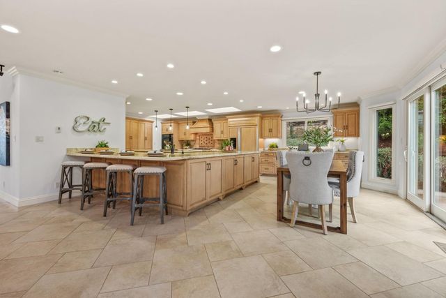 a kitchen with a dining table chairs and view of living room