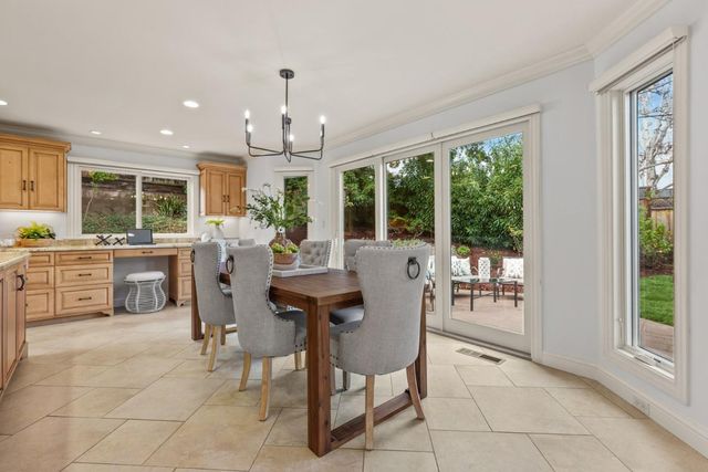 a view of a dining room and livingroom with furniture large windows a rug and a chandelier