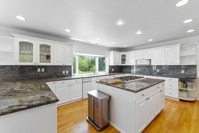 a kitchen with granite countertop a sink a counter top space and stainless steel appliances