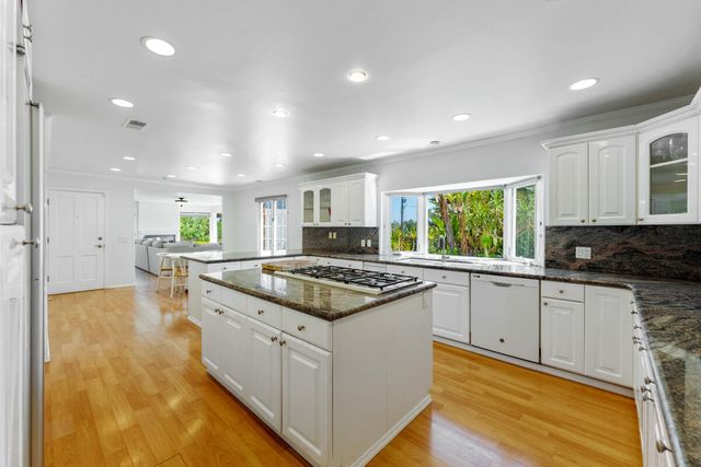 a kitchen with stainless steel appliances granite countertop stove a sink and a refrigerator