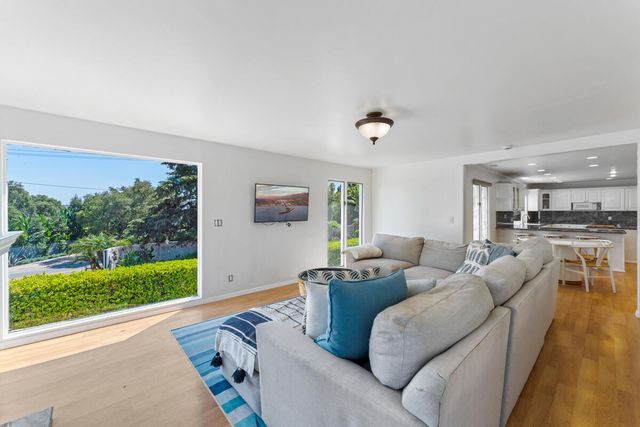 a living room with furniture and a open to kitchen view