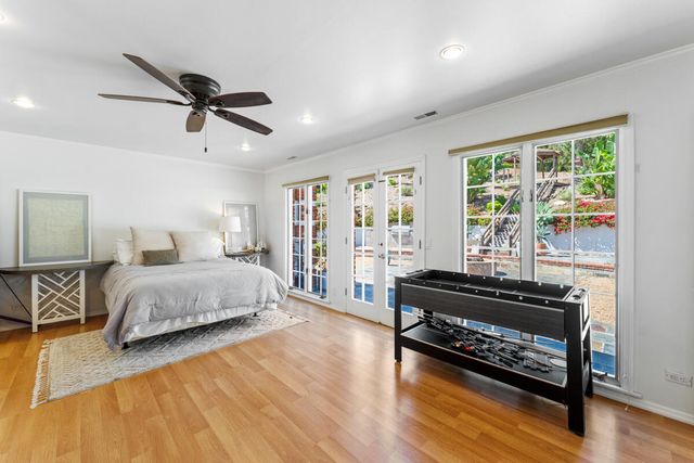 a spacious bedroom with a bed a dresser and a large window