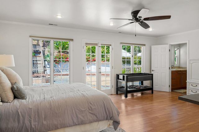 a bedroom with a bed a large window and furniture